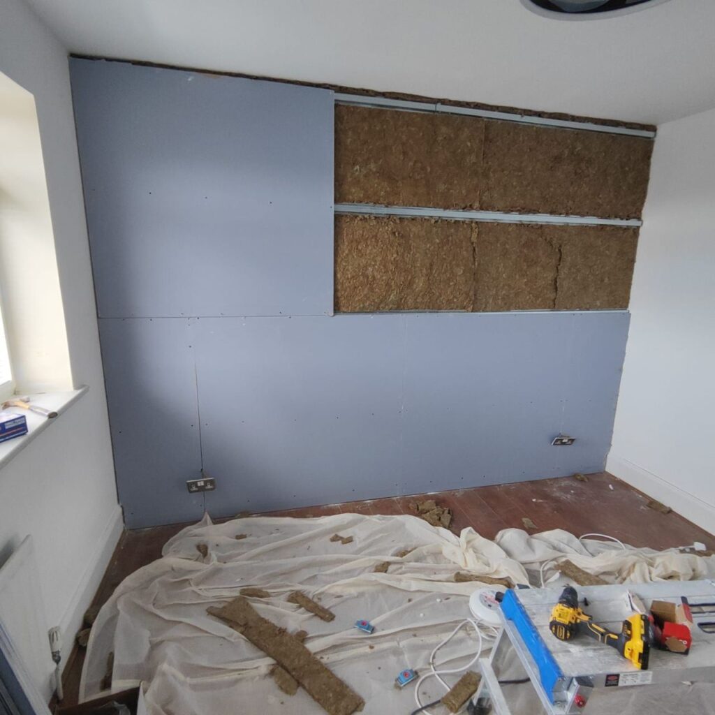 Acoustic plasterboard being applied to a wall