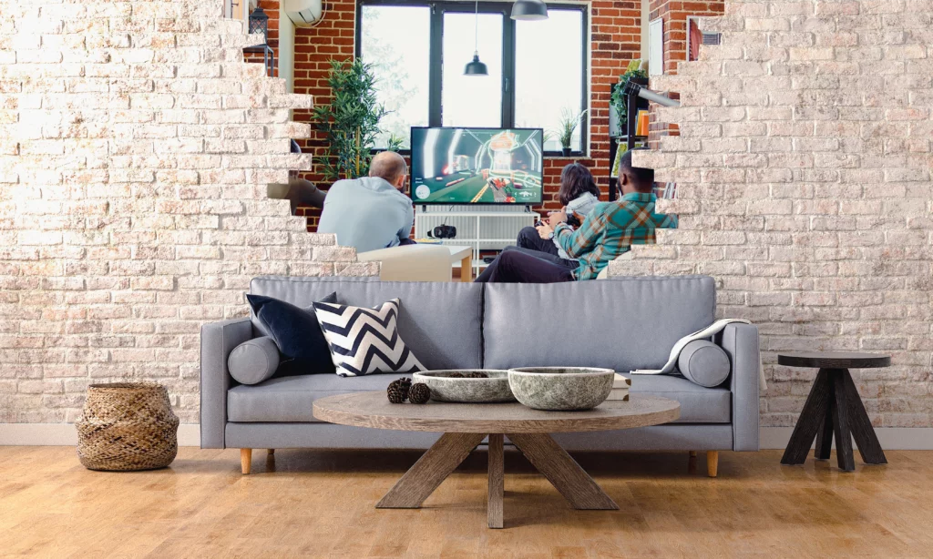 photograph imagined of a lounge with brick wall and a hole showing neighbours on the other side being noisy