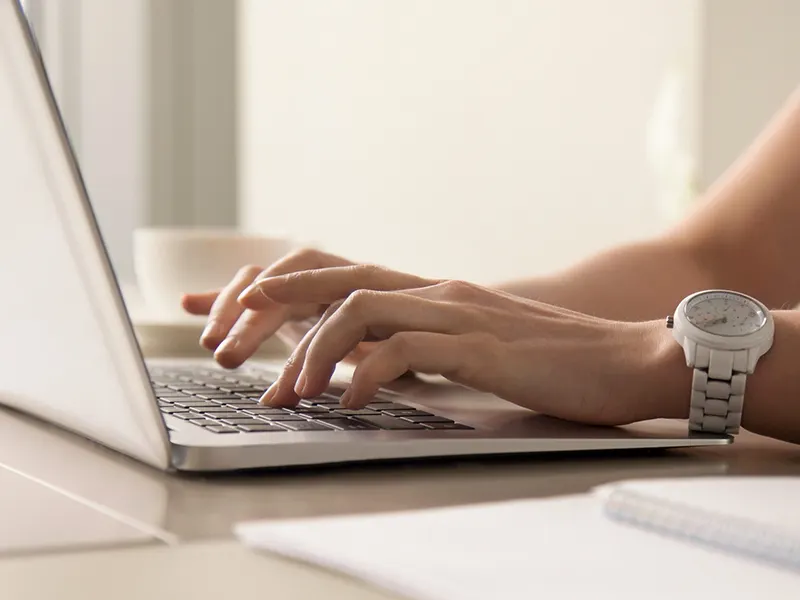 womans hands typing laptop workplace edited 1 2048x1535 1