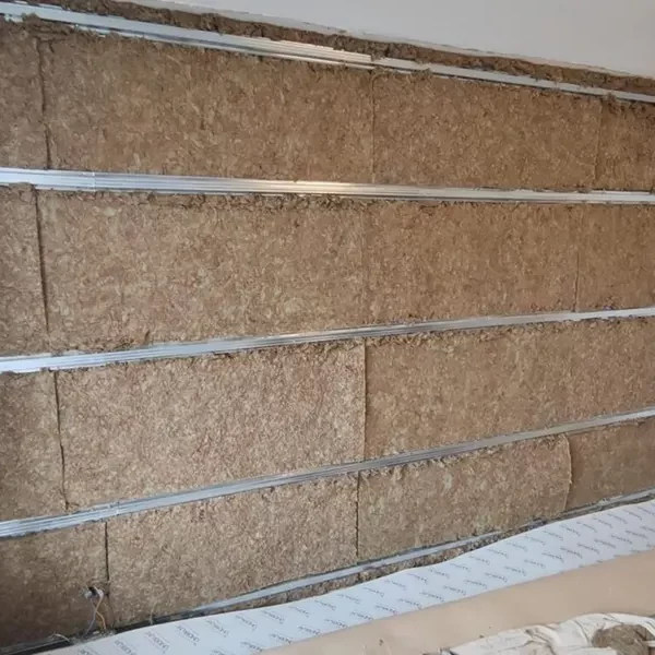 exposed wall soundproofing materials. Acoustic mineral installer between isolation clip and channels in a living room