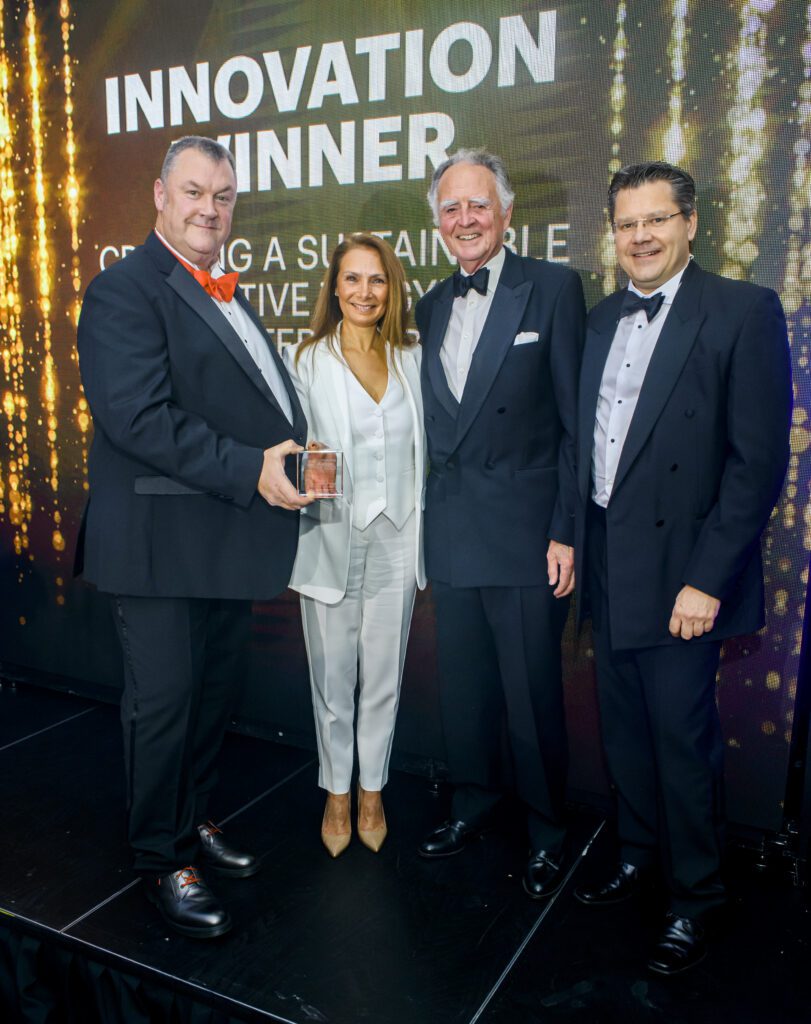 photo of Rick Parsons and Dawn Freeman at the 2023 Constructing Excellence awards with their trophy for winning the 'Innovations' award for a greener alternative to plasterboard